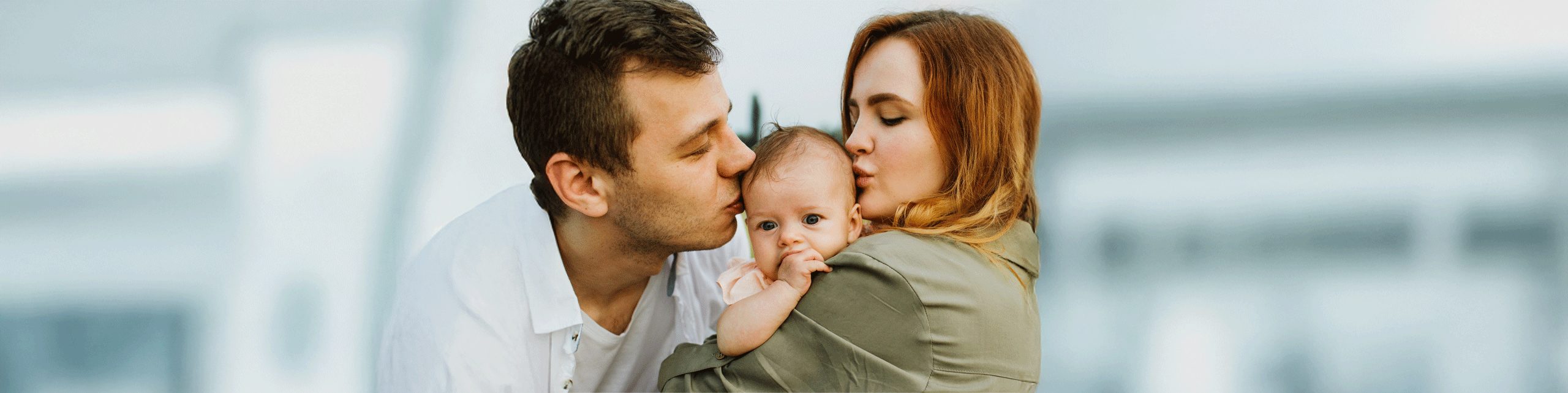 mom and dad kissing baby